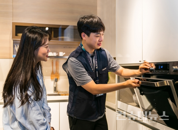 삼성전자서비스 수리 엔지니어가 고객에게 오븐 사용방법을 설명하고 있는 모습