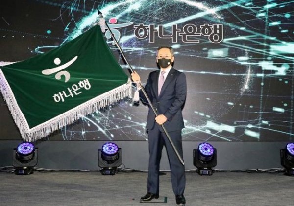 박성호 신임 하나은행장이 25일 서울 을지로 하나은행 본점에서 진행된 취임식에서 은행 깃발을 들고 있다. (사진=하나은행)